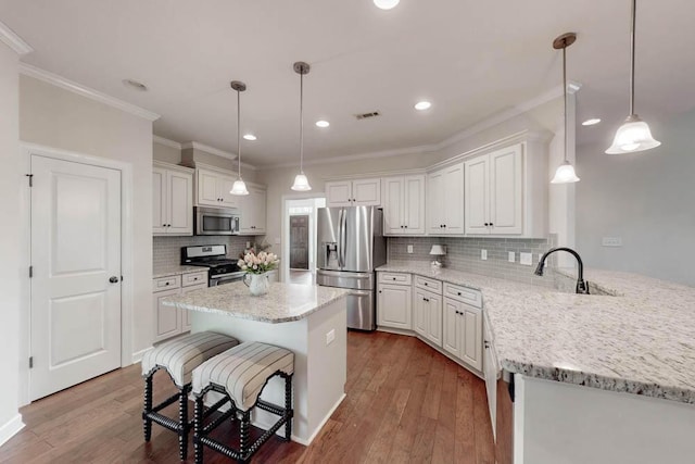 kitchen with backsplash, white cabinets, appliances with stainless steel finishes, and visible vents
