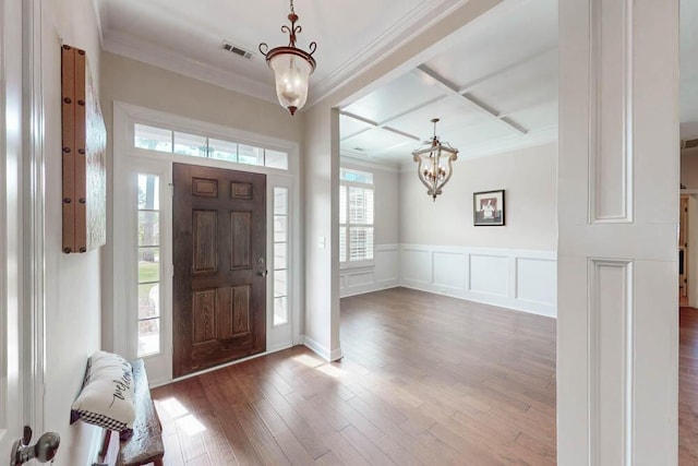 entrance foyer featuring crown molding, a chandelier, and coffered ceiling