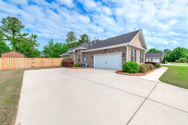 view of side of property with fence, an attached garage, brick siding, concrete driveway, and a lawn