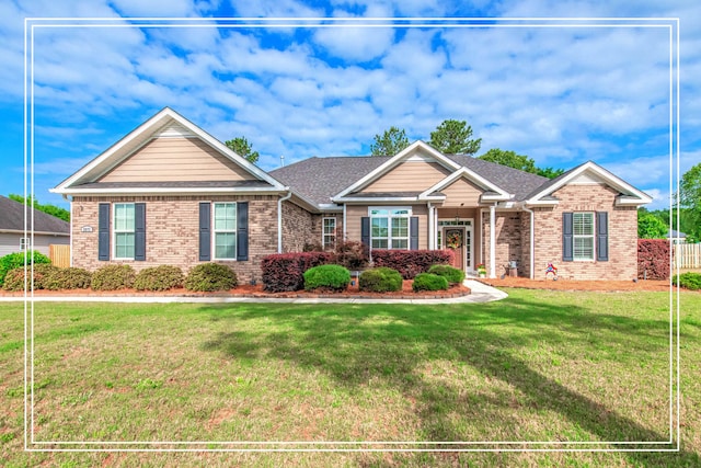 craftsman house with brick siding, a shingled roof, and a front lawn