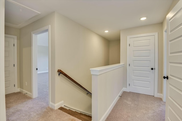 hall with light colored carpet, baseboards, an upstairs landing, and recessed lighting