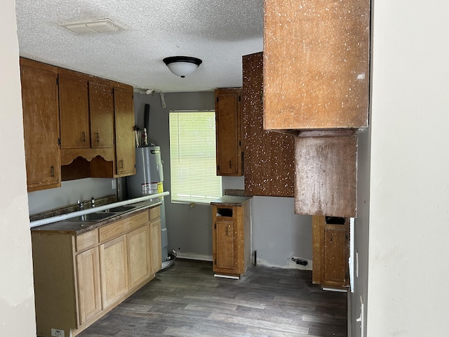 kitchen featuring dark hardwood / wood-style flooring, a textured ceiling, gas water heater, and sink