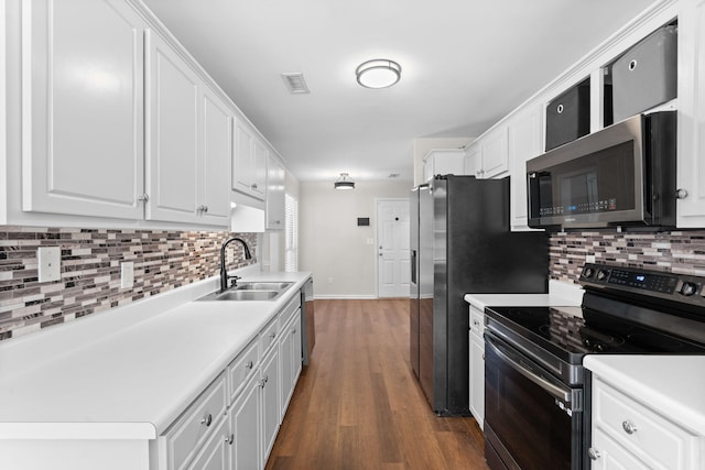 kitchen featuring dark hardwood / wood-style flooring, sink, white cabinets, tasteful backsplash, and stainless steel appliances