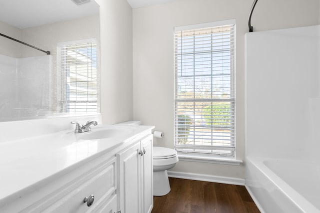 full bathroom with toilet, a healthy amount of sunlight, and hardwood / wood-style floors