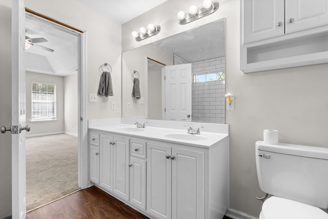 bathroom with wood-type flooring, toilet, ceiling fan, and vanity