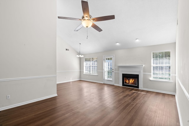 unfurnished living room with ceiling fan with notable chandelier, dark hardwood / wood-style flooring, and lofted ceiling