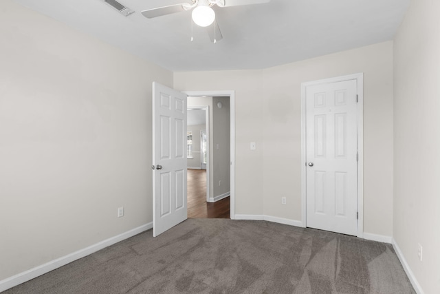 unfurnished bedroom featuring dark carpet and ceiling fan