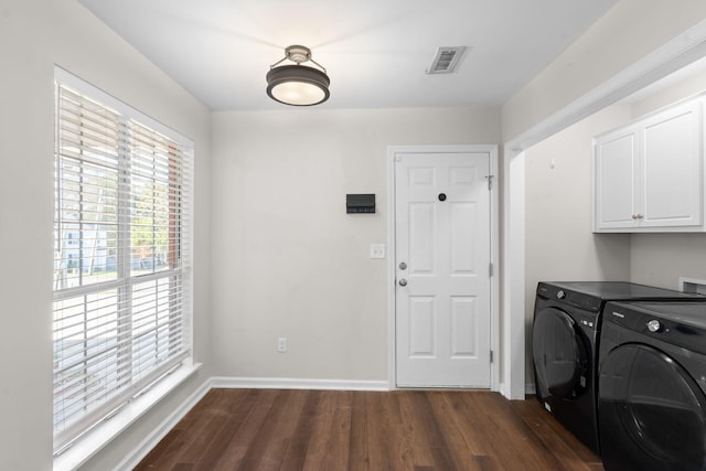 laundry room with cabinets, dark wood-type flooring, and washer and clothes dryer