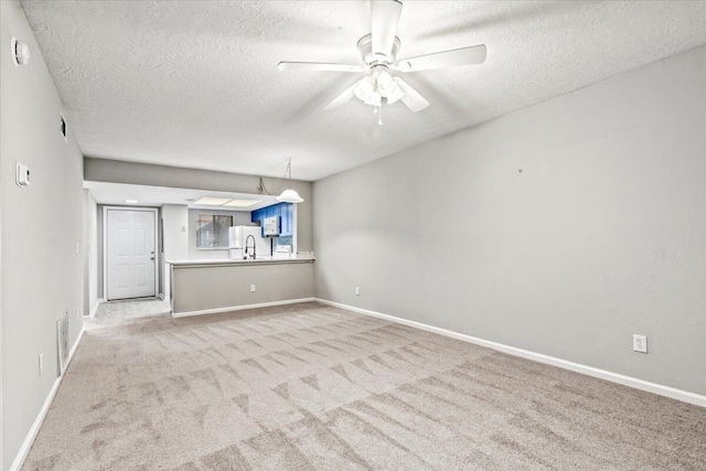 carpeted spare room with ceiling fan and a textured ceiling