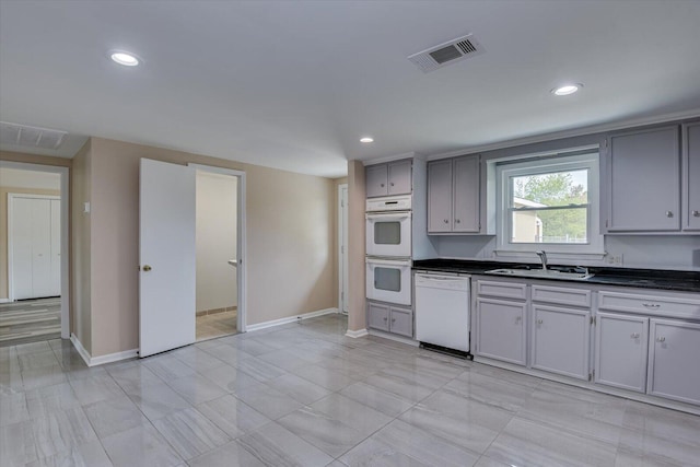 kitchen featuring gray cabinetry, sink, and white appliances