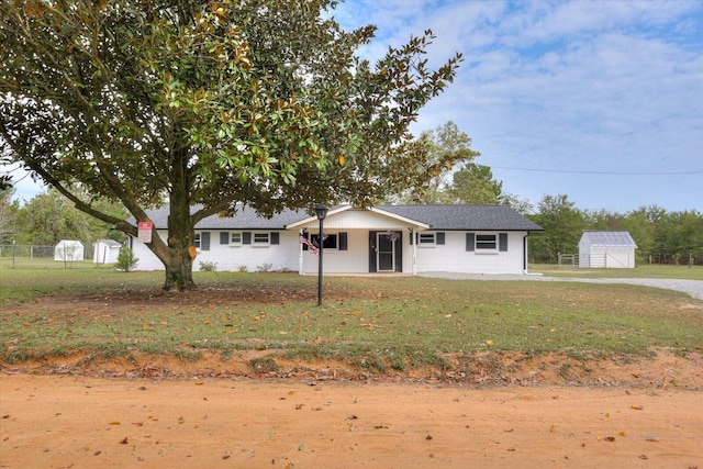 view of front of house with a front yard and a storage unit