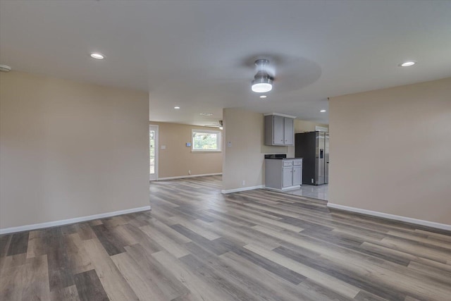 unfurnished living room featuring ceiling fan and light hardwood / wood-style flooring