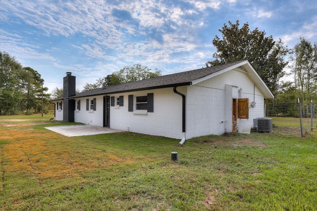 back of property with a yard, central AC unit, and a patio area