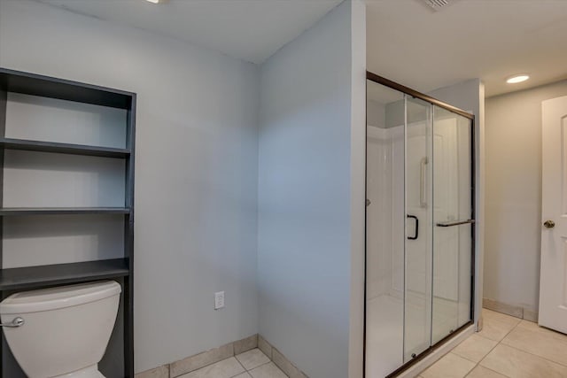 bathroom featuring walk in shower, tile patterned flooring, and toilet