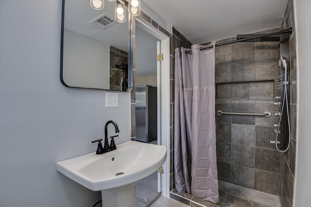 bathroom with a shower with curtain, sink, and tile patterned flooring