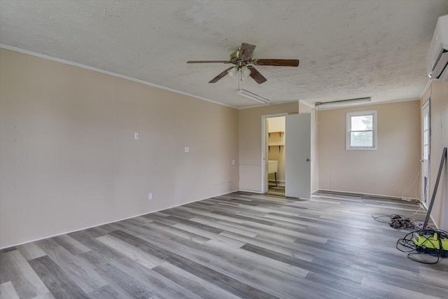 unfurnished room with ceiling fan, light hardwood / wood-style floors, a textured ceiling, and ornamental molding