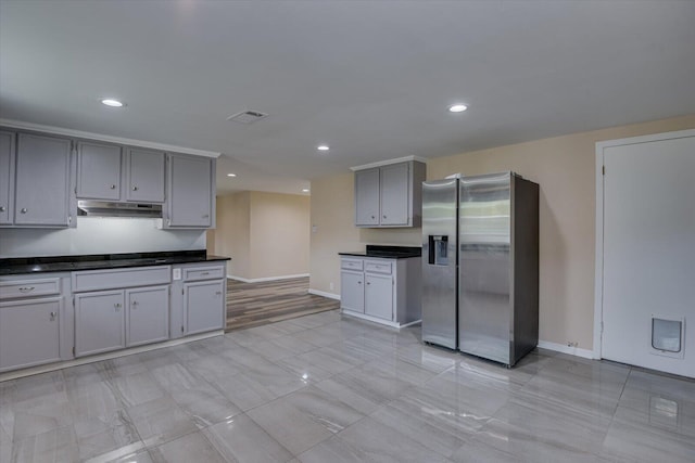 kitchen featuring stainless steel fridge and gray cabinetry