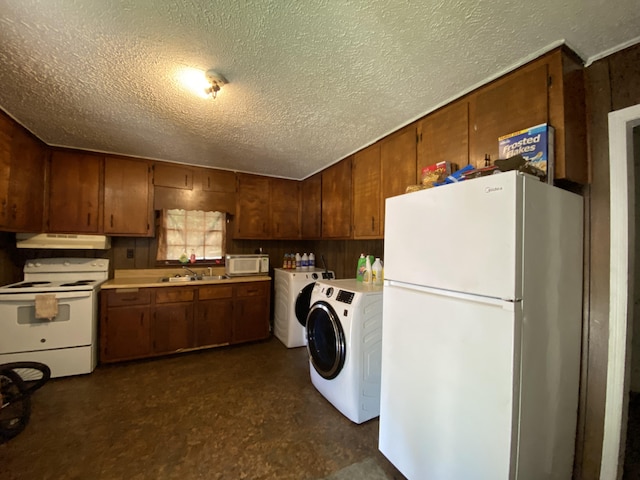 kitchen with washer / dryer, white appliances, wood walls, and sink