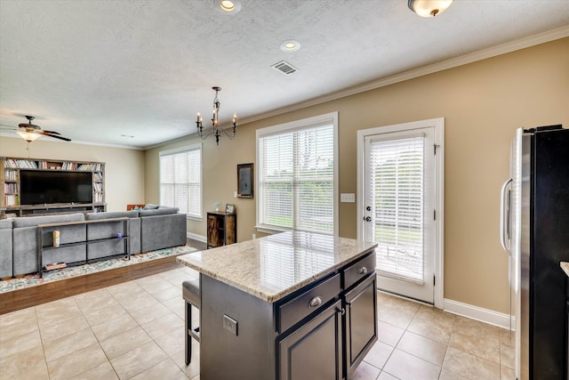 5558 Connor Dr, Evans, GA 30809 - kitchen with freestanding refrigerator, crown molding, light tile patterned floors, a breakfast bar area, and open floor plan