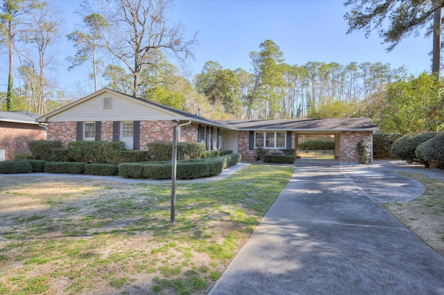 ranch-style house featuring a carport, a front yard, concrete driveway, and brick siding