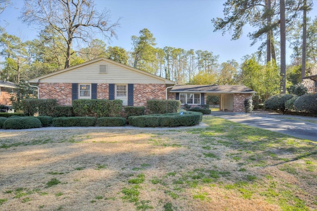 ranch-style home with brick siding, driveway, and a front lawn