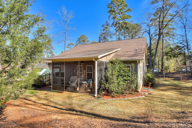 back of property with roof with shingles, a lawn, and a sunroom