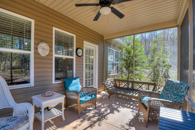 sunroom featuring wood ceiling and ceiling fan