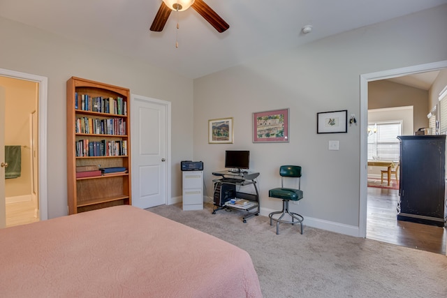 bedroom with light carpet, baseboards, a ceiling fan, and lofted ceiling