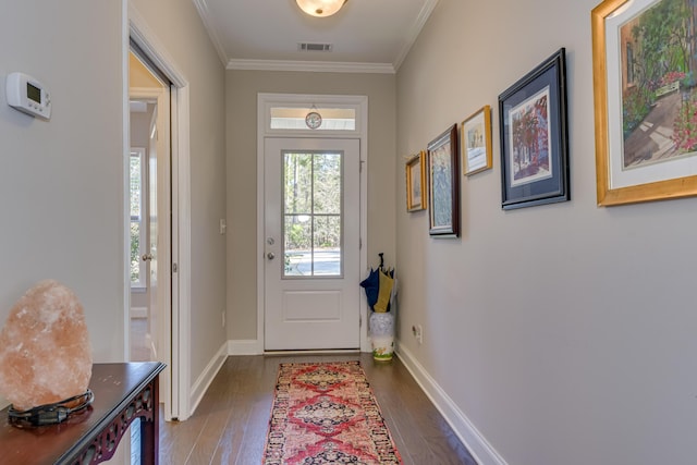 doorway to outside featuring baseboards, wood finished floors, visible vents, and crown molding