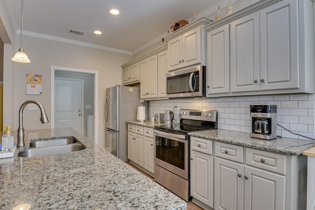 kitchen with visible vents, appliances with stainless steel finishes, ornamental molding, light stone countertops, and a sink