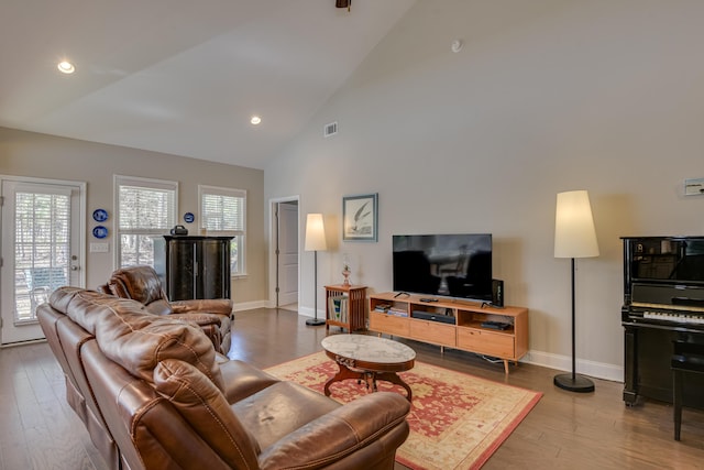 living room with baseboards, visible vents, wood finished floors, high vaulted ceiling, and recessed lighting