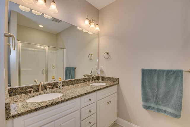 full bath featuring visible vents, a sink, a shower stall, and double vanity