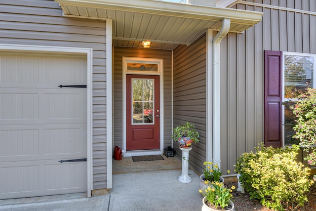 property entrance with board and batten siding and an attached garage