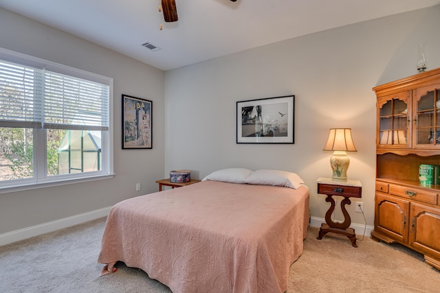 bedroom featuring light carpet, ceiling fan, and baseboards