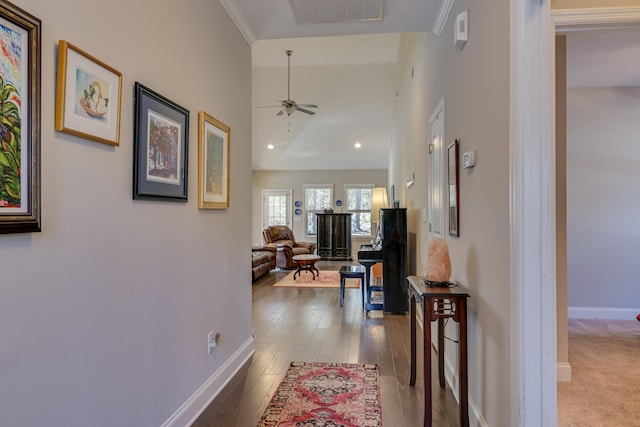 hall with recessed lighting, visible vents, a towering ceiling, wood finished floors, and baseboards