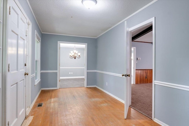 interior space featuring a textured ceiling, an inviting chandelier, and crown molding