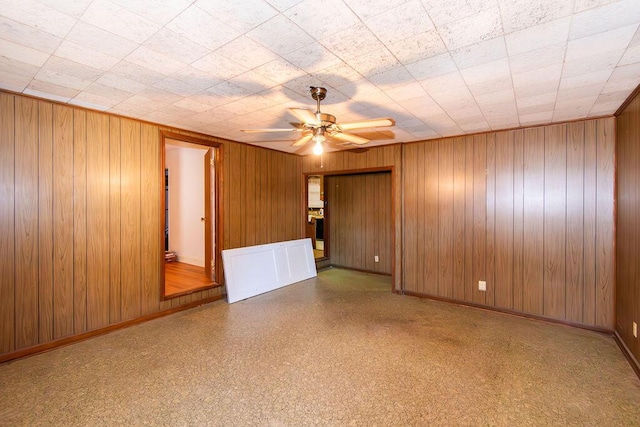 empty room with a ceiling fan and baseboards