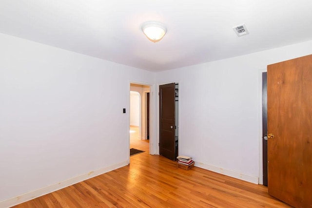 spare room featuring visible vents, light wood-style flooring, and baseboards