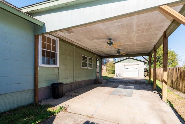 view of patio / terrace featuring an attached carport, fence, a ceiling fan, an outdoor structure, and concrete driveway