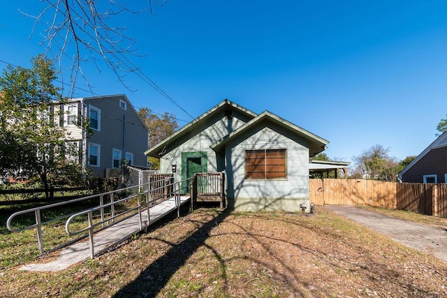 view of front facade with driveway and fence