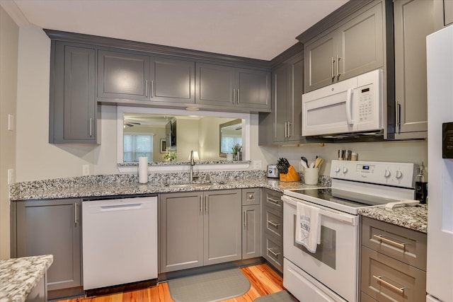 315 Coastal Cv, Mccormick, SC 29835 - kitchen with white appliances, a sink, light stone countertops, and light wood-type flooring
