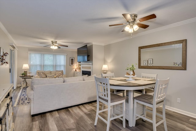 315 Coastal Cv, Mccormick, SC 29835 - dining room featuring ceiling fan, wood finished floors, crown molding, a fireplace, and baseboards