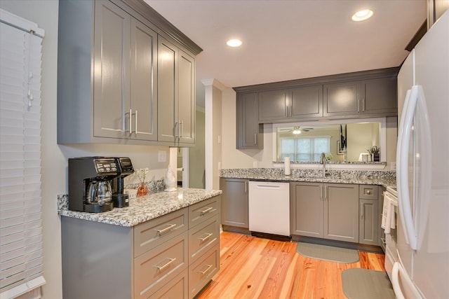 315 Coastal Cv, Mccormick, SC 29835 - kitchen with white appliances, a sink, gray cabinets, light wood finished floors, and light stone counters