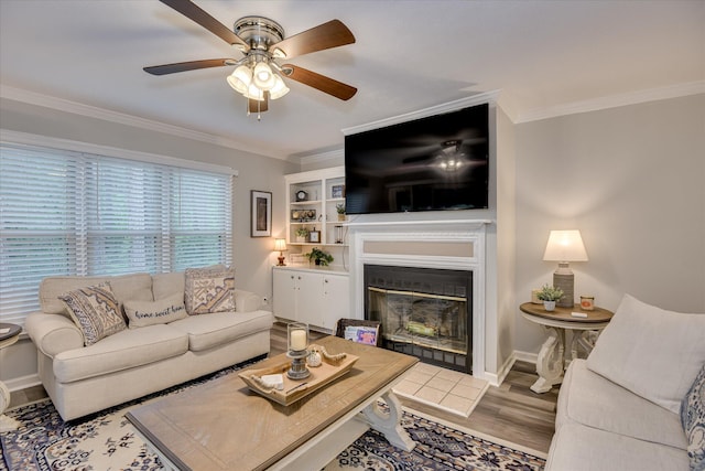 315 Coastal Cv, Mccormick, SC 29835 - living area featuring crown molding, wood finished floors, a ceiling fan, a glass covered fireplace, and baseboards