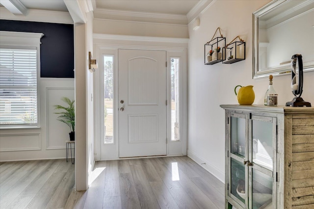 entrance foyer with crown molding and light hardwood / wood-style flooring