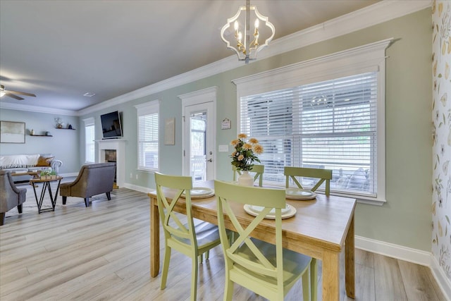 dining room featuring ceiling fan with notable chandelier, light hardwood / wood-style flooring, and ornamental molding