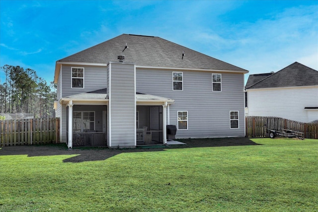 back of house featuring a lawn and a sunroom