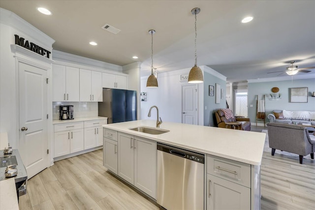 kitchen with refrigerator, white cabinetry, sink, hanging light fixtures, and stainless steel dishwasher