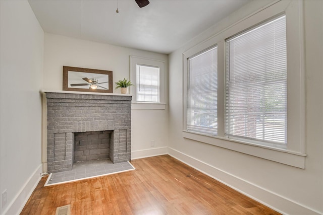 1847 Warren St, Augusta, GA 30904 - unfurnished living room with ceiling fan, a brick fireplace, baseboards, wood finished floors, and visible vents