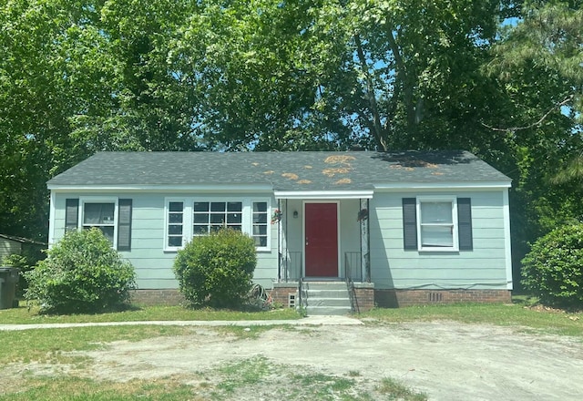 single story home with a shingled roof, entry steps, and crawl space